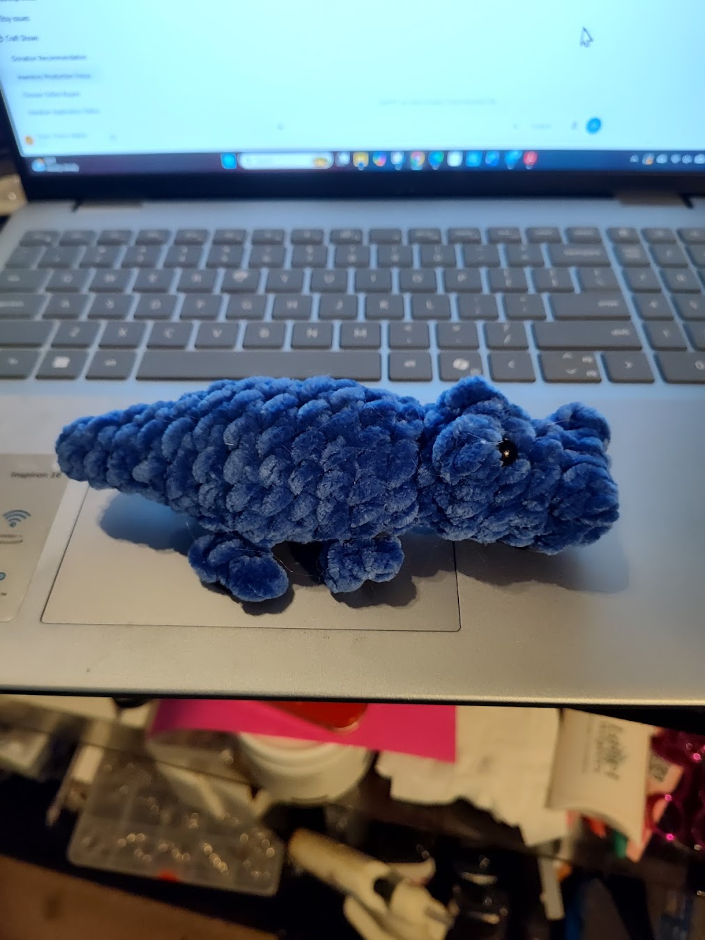 Dark blue crocheted mini alligator plush with safety eyes, approximately 4 inches long.