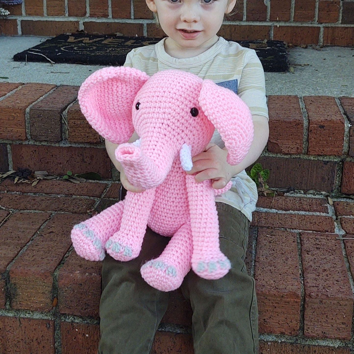 Pink Elephant in a childs arms. This is a large elephant