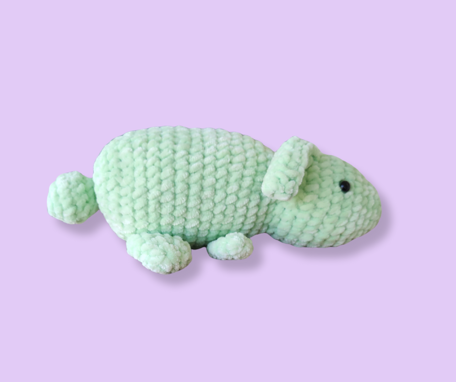 Handmade green crochet plush bunny made with soft plush yarn, shown on a light lavender background.