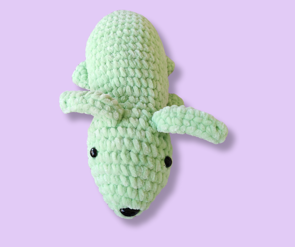 Handmade green crochet plush bunny made with soft plush yarn, shown on a light lavender background.