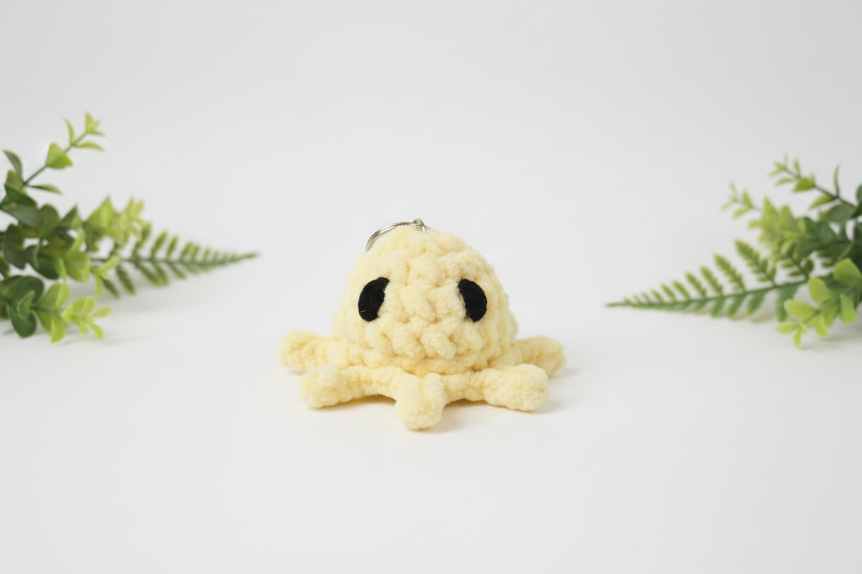 Yellow octopus keychain - white background with greenery